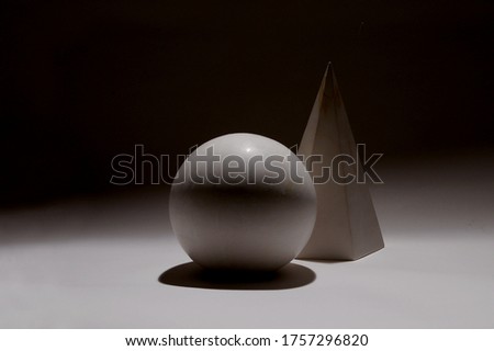 white globe and white cube on a black background and a white coating