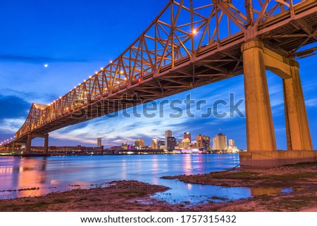 New Orleans, Louisiana, USA at Crescent City Connection Bridge over the Mississippi River at dusk.
