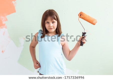 Little child painter doing renovation wall. Redecoration, repair and repaint concept.