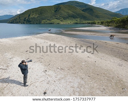 Wildlife photographer taking a bears pictures, Kamchatka peninsula, Russia.   