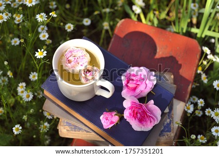 A cup of tea of ​​roses on books.Concepts of tea and books.

