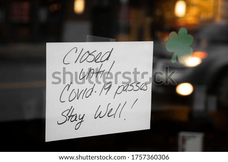 "Closed until Covid-19 passes. Stay Well!" sign in a storefront window