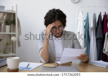 Upset young woman sit at desk feel frustrated with dismissal notice news in paperwork document, unhappy millennial female disappointed stressed with eviction notice or negative message in letter Royalty-Free Stock Photo #1757362091
