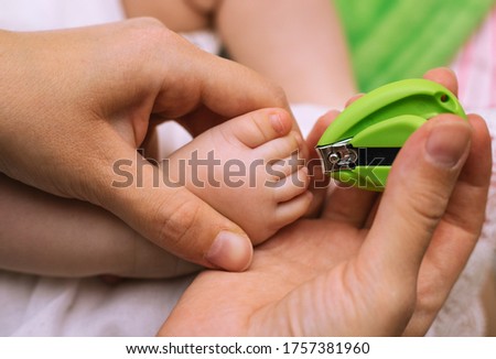 Nail clipping for a small child. Pedicure. Mom's little feet and hands. Hygiene for children.