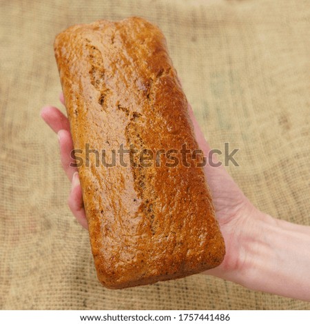 Gluten-free whole grain rye bread hold in hand on the sackcloth background. Healthy food concept..
