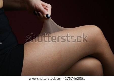 woman's hand pulling tights on her leg Royalty-Free Stock Photo #1757462051