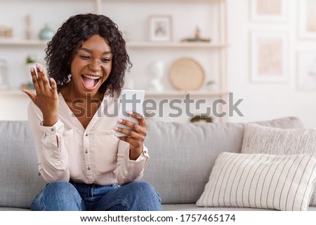 Overjoyed black girl celebrating success with smartphone at home, received good news, yelling with excitement, copy space Royalty-Free Stock Photo #1757465174