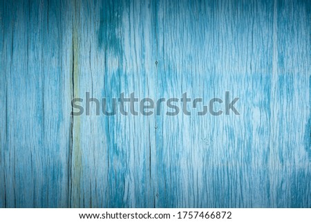 artistic background of old wooden faded cracked plywood painted blue paint