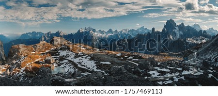 An aerial shot of the breathtaking Cadini di Misurina mountains covered in snow gleaming under the cloudy sky