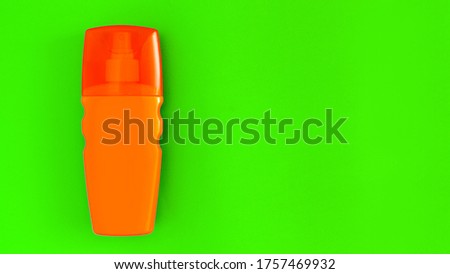 orange bottle with a spray of sunblock cream for tanning lies on a green background top view with copy space, nobody.