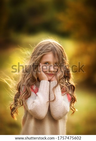 Portrait of a young pretty long haired girl posing on an autumn background. Copy space.