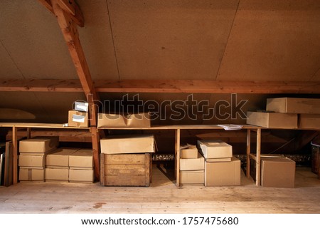 Old wooden attic interior with old cardboard boxes for storage or moving, close-up Royalty-Free Stock Photo #1757475680