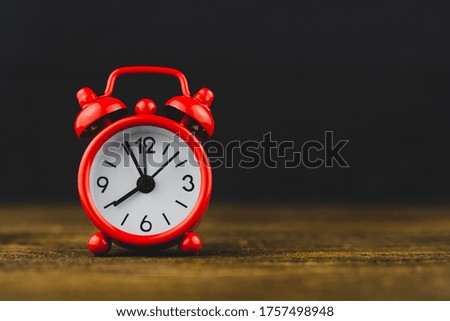 red alarm clock on black background, time concept