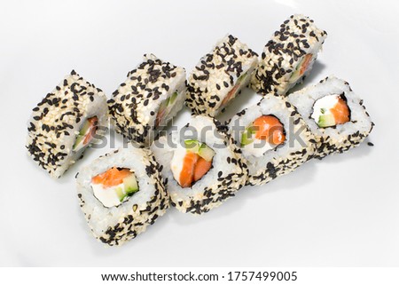 Japanese roll of rice, sesame seeds, cream cheese, cucumber, salmon on a white background