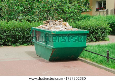 Container with solid household and construction waste. Waste recycling. Caring for the environment Royalty-Free Stock Photo #1757502380