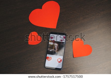 phone with red hearts on table close up