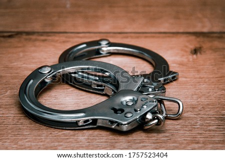 Handcuffs on a wooden background. Close-up. Police handcuffs. The concept of punishment for crime.
