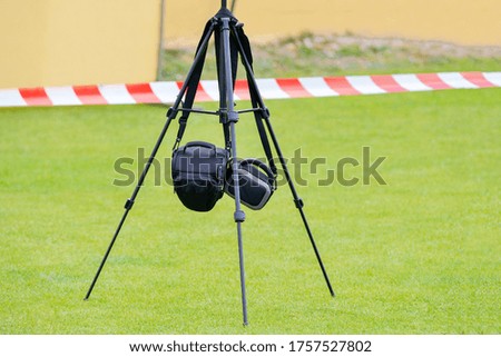 photo tripod with hanging photo bags on green grass