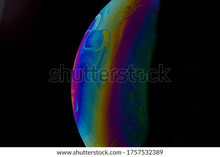 colored soap bubble. worlds. planets on black background.