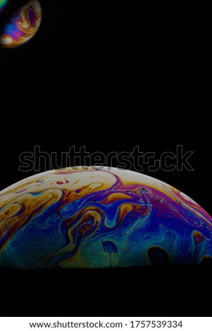 colored soap bubble. worlds. planets on black background.