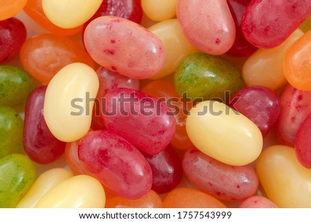 Fruity sweets, tasty sugary candies and sweet treat concept with picture of full frame background of mixed flavour and colours jelly beans with copy space
