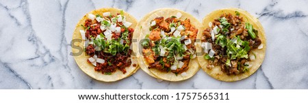 row of mexican street tacos with carne asada and al pastor in corn tortilla wide banner composition Royalty-Free Stock Photo #1757565311