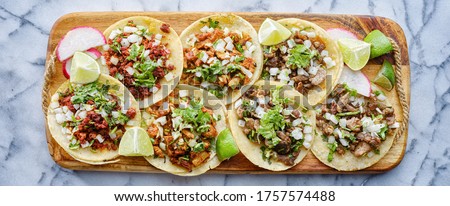 wooden tray full of mexican street tacos