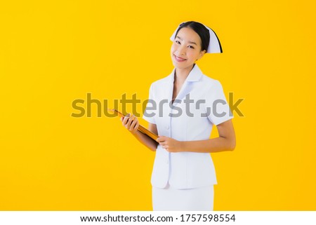 Portrait beautiful young asian woman thai nurse show empty white board and work at clinic or hospital on yellow isolated background