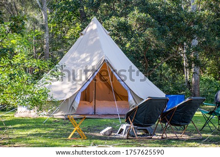 Glamping camping teepee tent and chairs at the campsite. Royalty-Free Stock Photo #1757625590