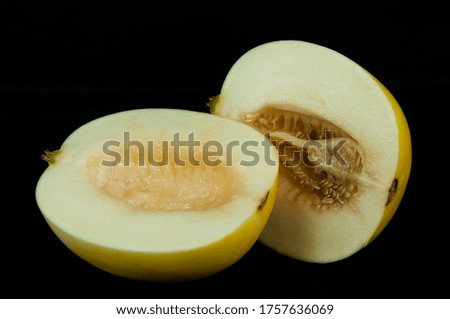 art photo ripe melon cutting in half with seeds on a black background