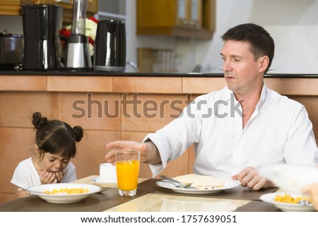Father and overbearing daughter eating breakfast together. Anorexia child. Royalty-Free Stock Photo #1757639051