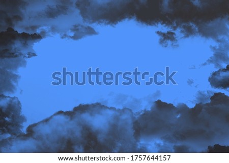 A blue sky surrounded by black clouds