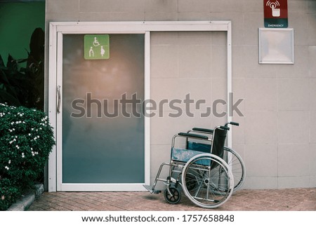 Empty wheelchair standing at a Toilet in filling station