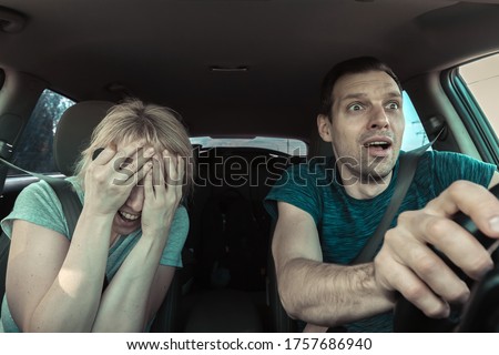 Incident on road. View inside car of driver man and passenger woman frightened of accident or collision while driving. Fear of young people from crash. Unsafe fast drive, danger of vehicle damage Royalty-Free Stock Photo #1757686940