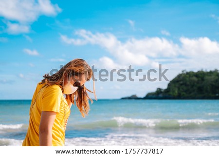Young asian woman travel on the beach in Thailand,Summer concept travel.Women with face mask travel on the beach.