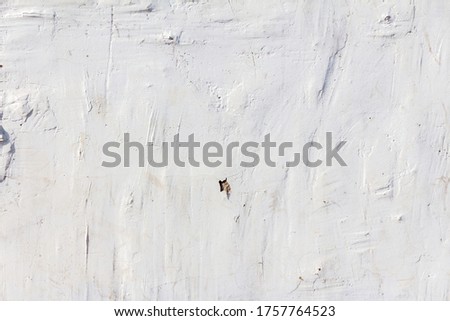 white plastered uneven wall of background or texture with spots and lines from the trowel