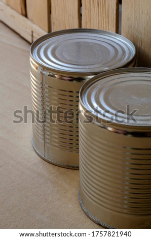 Canned food in cans. Two metal shut jars of ready-to-eat food. Long-term food products. Top view at an angle. Selective focus.