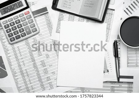 Top view of modern black office desk with notebook, pencil, financial statements and a lot of things. Flat lay table layout.