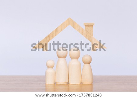 Wooden figurines representing family with house model. Concept of family in the future