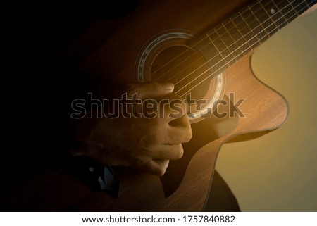 Closeup hand while playing the acoustic guitar 