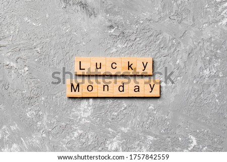 lucky monday word written on wood block. lucky monday text on cement table for your desing, concept.