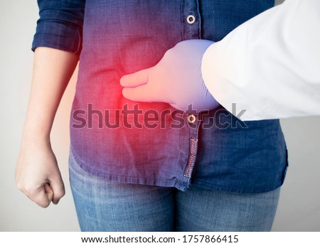 A woman suffers from pain in the appendix. Acute appendicitis, Crohn's disease, or inflammatory bowel disease. Surgeon examination and preparation for laparoscopic appendectomy Royalty-Free Stock Photo #1757866415