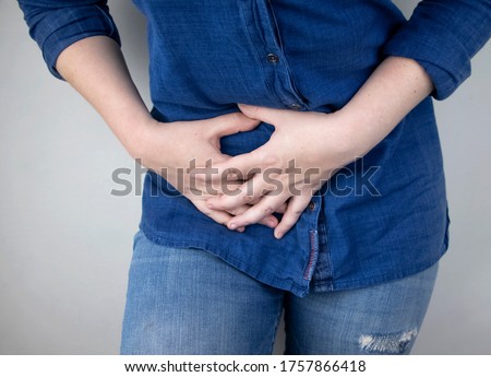 A woman suffers from pain in the appendix. Acute appendicitis, Crohn's disease, or inflammatory bowel disease. Surgeon examination and preparation for laparoscopic appendectomy Royalty-Free Stock Photo #1757866418