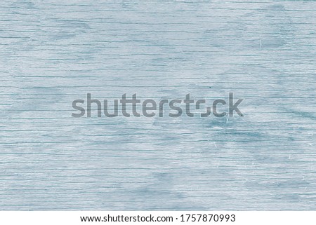 Texture of old wood panel with blue peeling paint with different horizontal lines. Background for text or design.