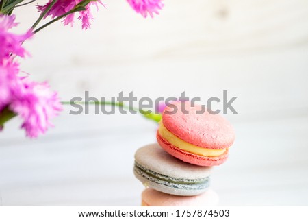 colorful macaroons on wooden background wihr lilac flowers
