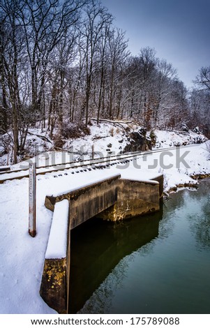 Snow covered railroad bridge over a creek in rural Carroll County, Maryland.
