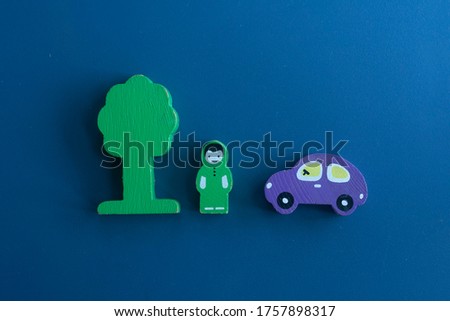  Wooden figurines of a tree, a man and a car on a blue background