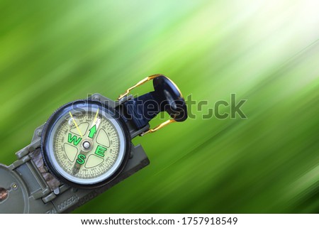 round compass as symbol of tourism, travel and outdoor activities on green background