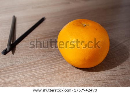 Citrus fruit grapefruit in whole. Wooden table and pencils. High quality photo