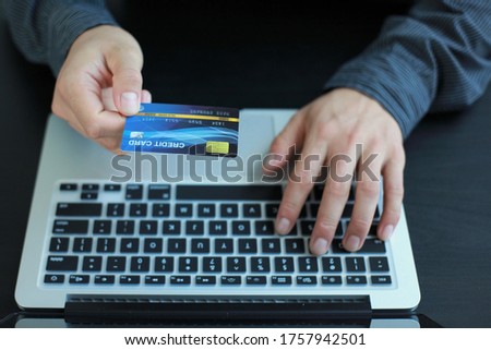 Young businessmen use credit cards for online shopping to receive bonus points from their use and are fast and easy with laptops.